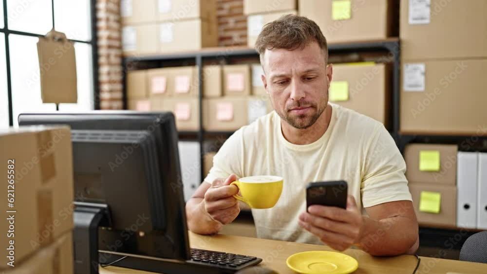 Young man ecommerce business worker using smartphone drinking coffee at office Young man ecommerce business worker using smartphone drinking coffee at office
