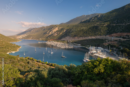 Fototapeta Naklejka Na Ścianę i Meble -  Panoramic landscape of a lagoon and marina full of sail boats between forested mountains, Kas, Turkey