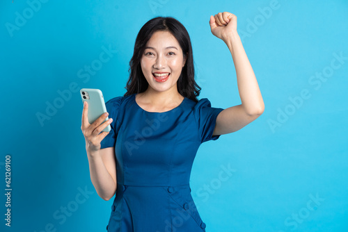 Portrait of beautiful woman in blue dress, isolated on blue background.