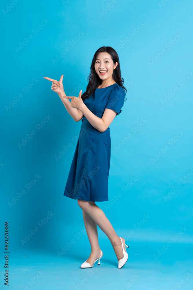 Portrait of beautiful woman in blue dress, isolated on blue background Portrait of beautiful woman in blue dress, isolated on blue background