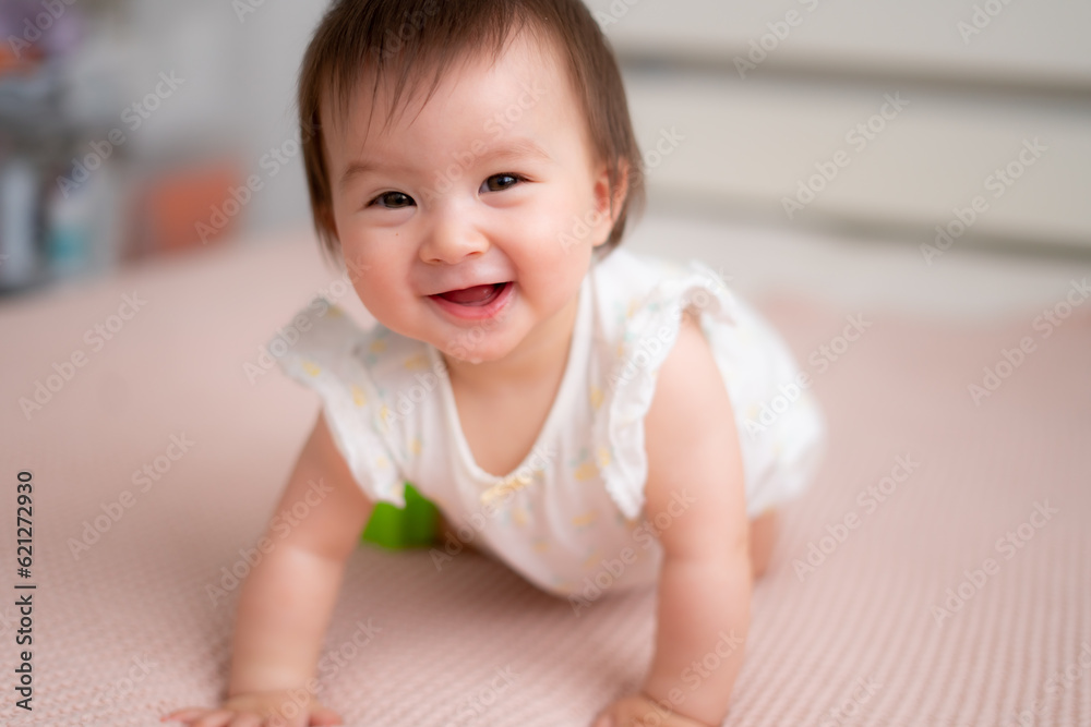 lifestyle home portrait of 9 months old mixed ethnicity Asian Caucasian baby girl playing happy and carefree on bed crawling and handling color blocks in childhood and nursery concept lifestyle home portrait of 9 months old mixed ethnicity Asian Caucasian baby girl playing happy and carefree on bed crawling and handling color blocks in childhood and nursery concept