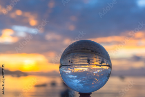 Fototapeta Naklejka Na Ścianę i Meble -  sunset sunrise view inside crystal ball..The natural view of the sea and sky are unconventional and beautiful. .A image for a unique and creative travel idea.