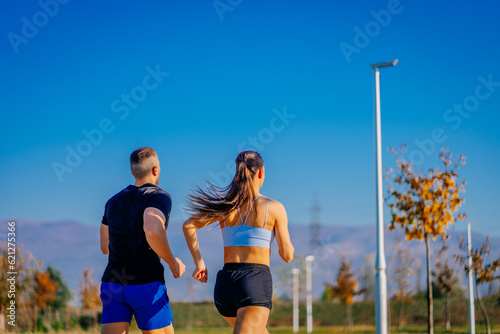 Back view photo of two people jogging