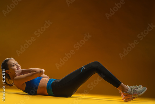 Fit woman stretching warming up - isolated yellow background