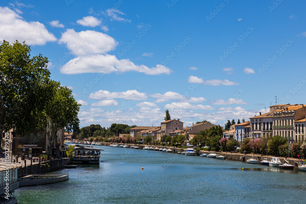 Façades le long du Quai Commandant Réveille à Agde donnant sur le fleuve Hérault et ses petits voiliers amarrés