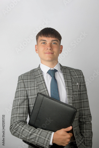 Young entrepreneur wearing a suit and tie holding a folderr photo