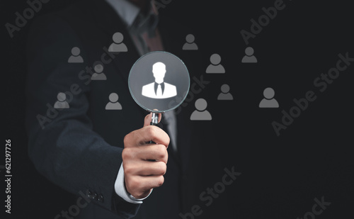 Businessman holding magnifying glass focus to manager icon, select leader or employees, Headhunting, Recruitment business and human resource management.