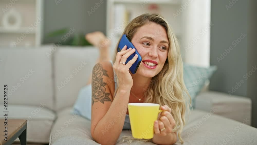 Young blonde woman talking on smartphone drinking coffee at home Young blonde woman talking on smartphone drinking coffee at home
