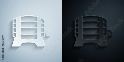 Paper cut Wooden barrel on rack with stopcock icon isolated on grey and black background. Paper art style. Vector