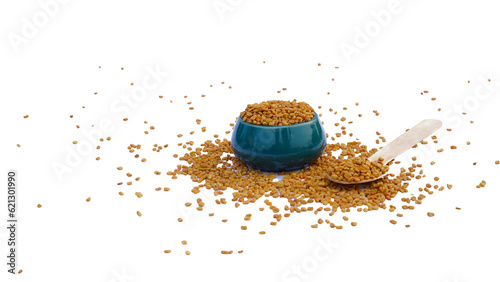 fenugreek seeds in wooden bowl and spoon isolated on white background. Spices and food ingredients. photo