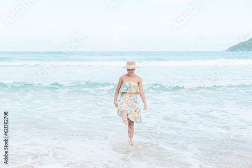 With a sense of wonder, a happy woman discovers paradise on her beach travel journey, relishing in the beauty and treasures the shoreline unveils.