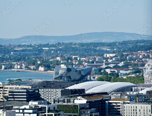 view of the district of confluences in Lyon with the very modern architecture of the confluence museum and in the background the Lyon countryside and its hills in summer. photo