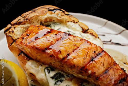 Salmon fillet steak with ciabatta and sauce on a plate