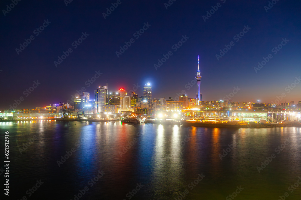 Night city of Auckland New Zealand. Glowing skyscrapers, bay and seaport of Auckland.