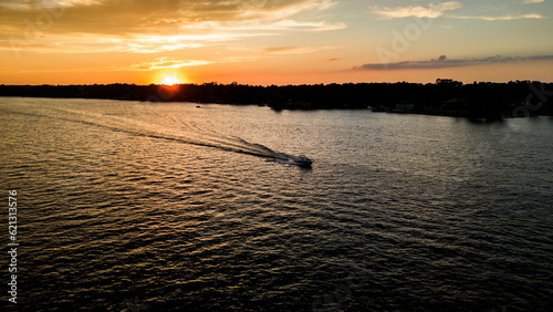 Boat cruising on lake during summer sunset