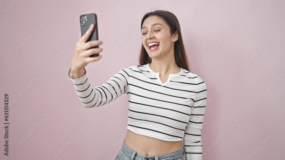 Young beautiful hispanic woman smiling confident having video call over isolated pink background Young beautiful hispanic woman smiling confident having video call over isolated pink background