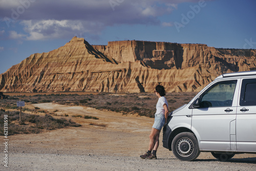 Femme brune accoudée à un van dans le desert des Bardenas Reales photo