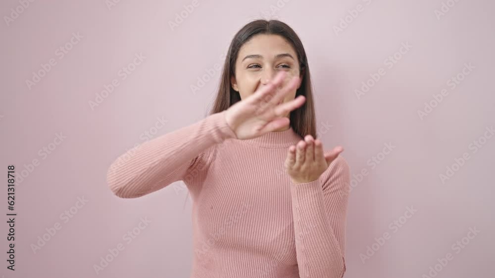 Young beautiful hispanic woman smiling confident doing spend money gesture over isolated pink background Young beautiful hispanic woman smiling confident doing spend money gesture over isolated pink background