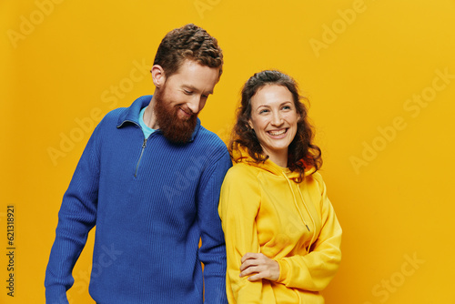 Man and woman couple smiling cheerfully and crooked with glasses, on yellow background, symbols signs and hand gestures, family shoot, newlyweds.