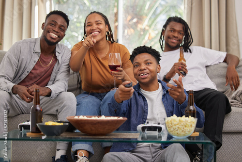 Television, relax and friends on a sofa with beer and popcorn for movie, film or streaming in their home. Group of people, watching tv and smile in living room together with entertainment on weekend
