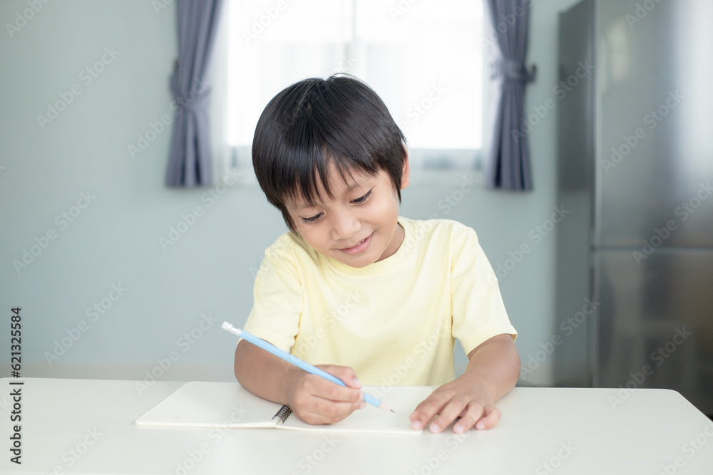 Happy boy kid earning and writing with smiling face Happy boy kid earning and writing with smiling face