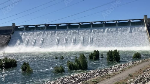 View of the water rushing over the spillway of the Grand Coulee Dam into the Columbia River. The water power is converted to hydroelectricity at this historic site - Eastern Washington, USA photo