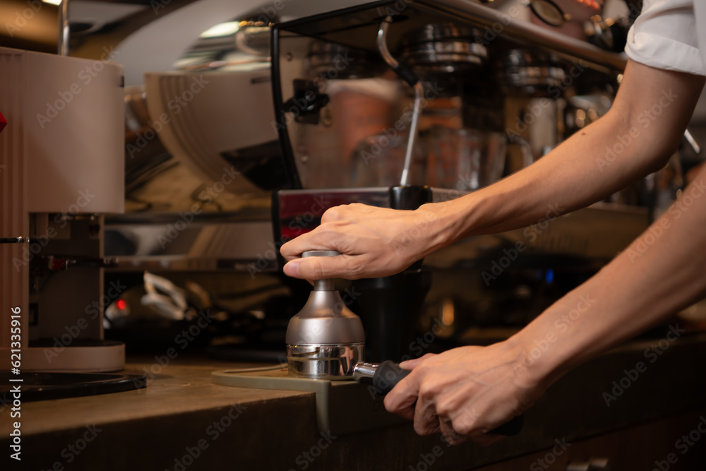 Close-up of barista hands using Portafilter for making espresso.