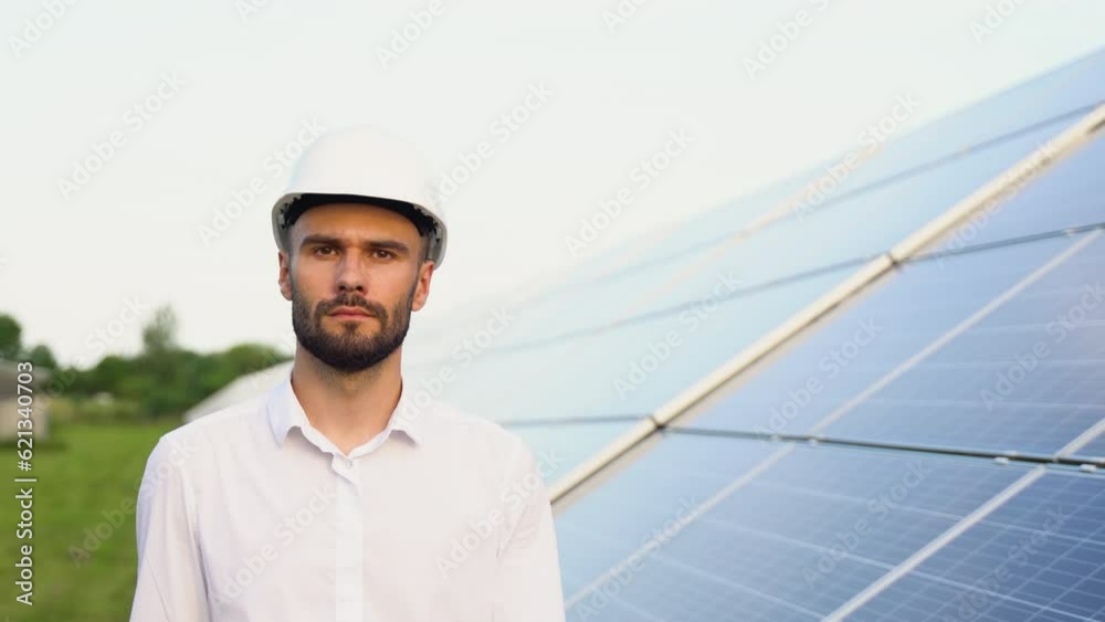 Solar power plant with engineer in protective workwear walking and examining photovoltaic panels. Concept of alternative energy and its maintenance Solar power plant with engineer in protective workwear walking and examining photovoltaic panels. Concept of alternative energy and its maintenance