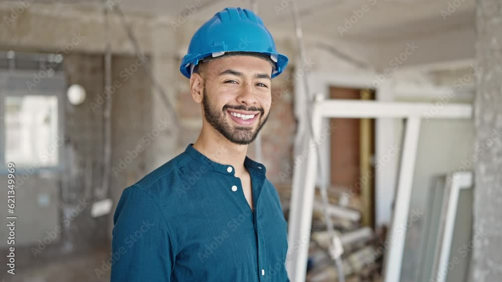 Young hispanic man architect wearing hardhat smiling at construction site Young hispanic man architect wearing hardhat smiling at construction site