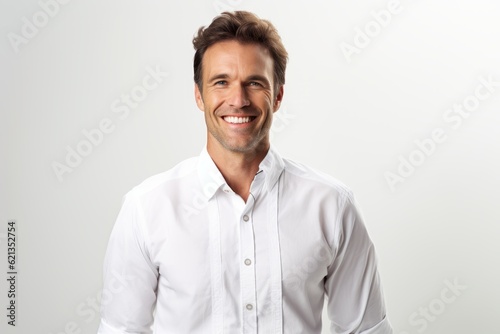 Portrait of a handsome young man smiling against a white background.