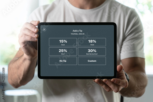 Man holding a tablet with tipping screen inside a restaurant photo