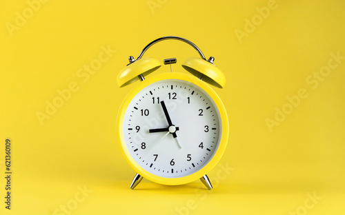 Yellow alarm clock on a colored yellow background. Monochrome. Minimalism. Concept of time, planning.