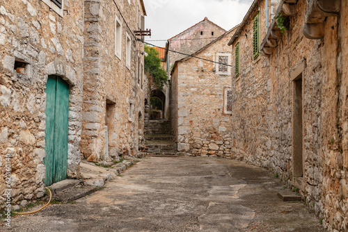Stone houses and bell tower of the village Velo Grablje on Island Hvar in Croatia, founded in the 14th century.  photo