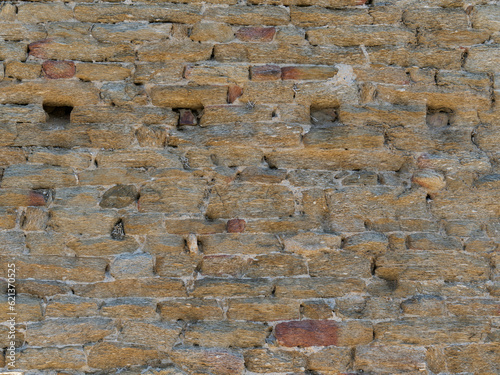 Dry stone wall texture, in the Provence style (France) around Bormes-les-Mimosas village, with a several deadeye holes visible photo