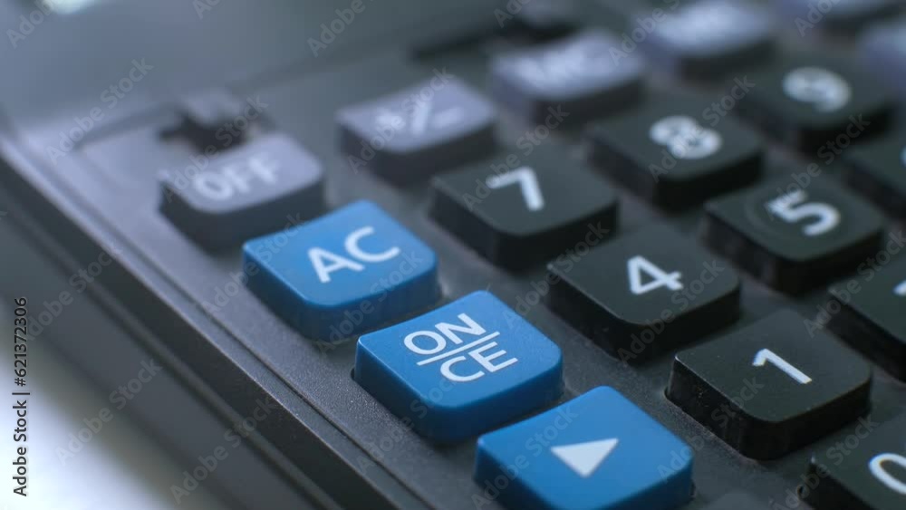 pressing the on button on the calculator with your finger. turn on. close up pressing the on button on the calculator with your finger. turn on. close up