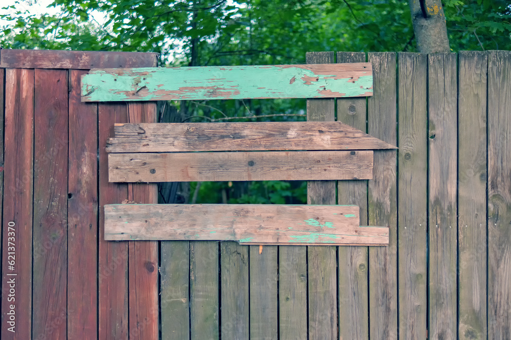 Wooden fence made of different boards Wooden fence made of different boards