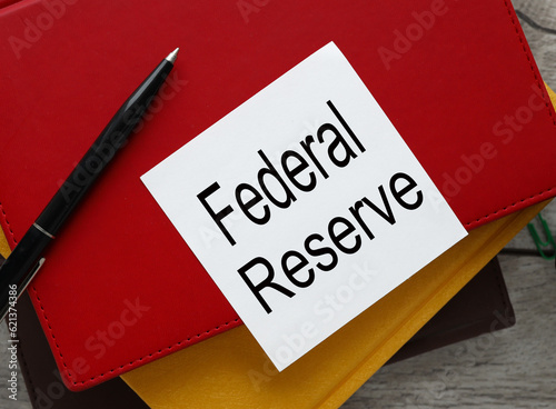 The Federal Reserve view from above. workspace with text on a white sticker on a red notepad.