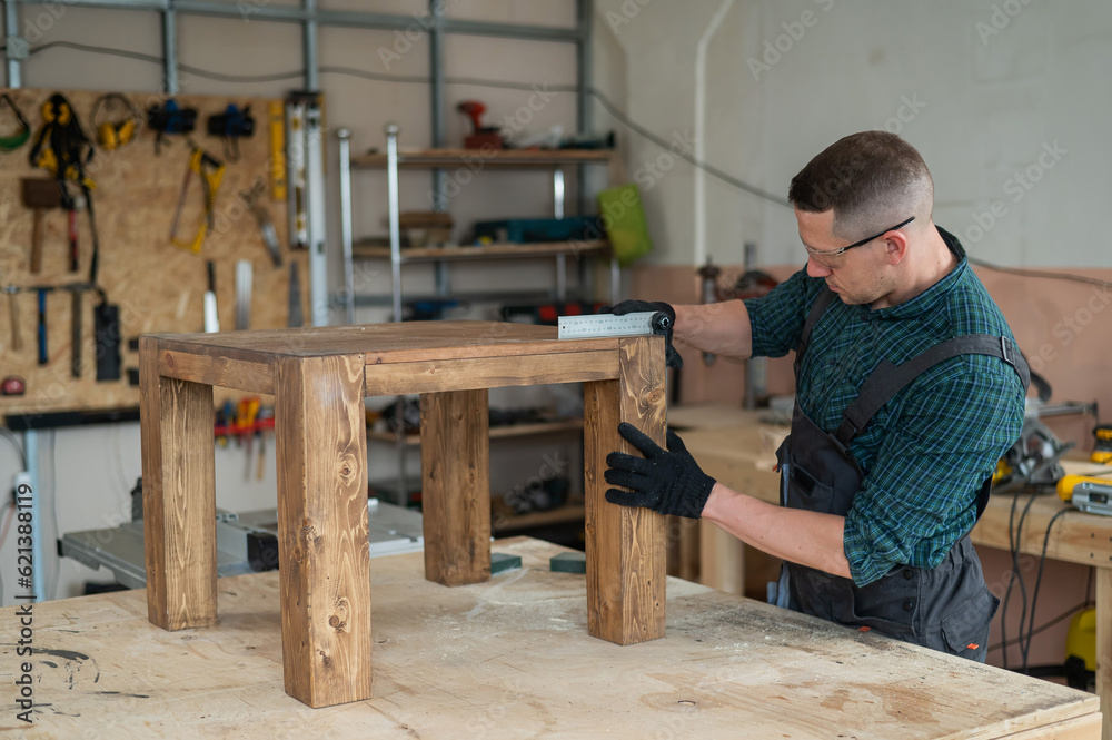 Male carpenter finishing work on wooden table in workshop. Male carpenter finishing work on wooden table in workshop.