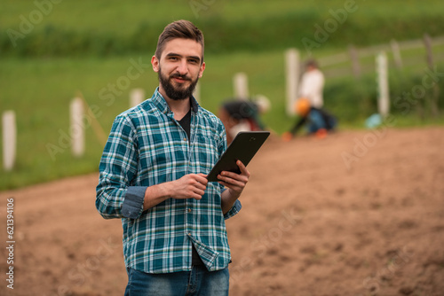 Male farmer plantation checking quality by tablet agriculture modern technology concept smart farming agronomist checking soil quality on the field.