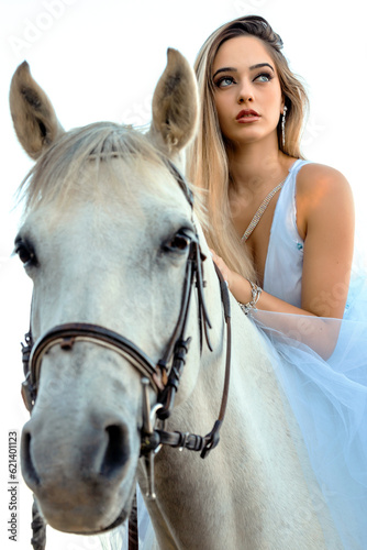 blonde girl riding a white horse
