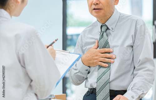 薬局で病気を説明する中高年男性と薬剤師・調剤師（肺炎・胸痛・心臓病・動悸・息切れ）
