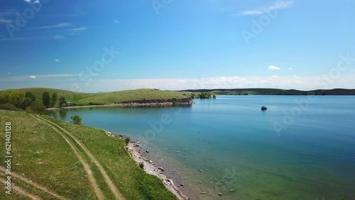 Wallpaper Mural Aerial: Drone Flying Backward Over Boat On Lake Near Green Hills Against Blue Sky During Sunny Day - Billings, Montana Torontodigital.ca