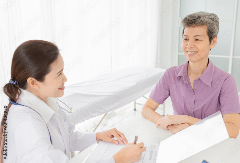Fototapeta premium asian patient talk with doctor in mental health clinic, she screening and write patient information on patient chart, elderly healthcare promotion