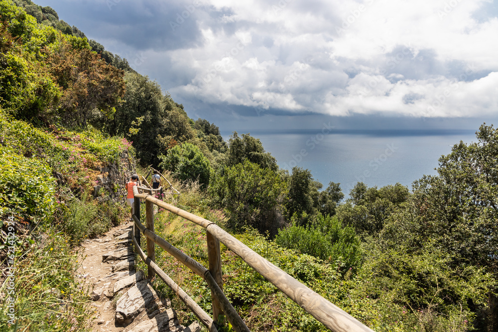 Unrecognized hikers trekking along the scenic Vernazza Monterosso trail in the popular 5 villages Cinque Terre trail in Italy