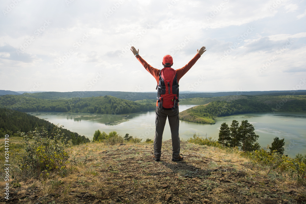 Man traveler on mountain summit enjoying nature view with hands raised. Travel lifestyle wanderlust adventure concept summer vacations outdoor Man traveler on mountain summit enjoying nature view with hands raised. Travel lifestyle wanderlust adventure concept summer vacations outdoor