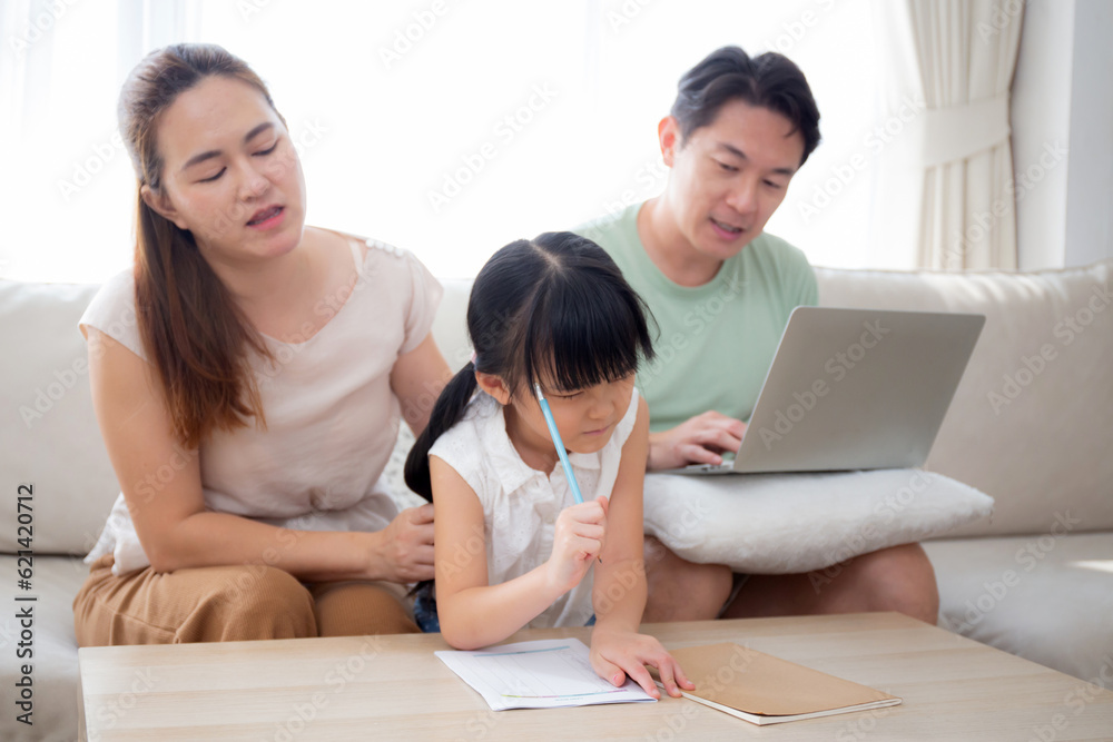 Happy family with mother teaching homework with daughter and father working with laptop on sofa in living room at home, mom explaining schoolwork with kid together, lifestyles and education. Happy family with mother teaching homework with daughter and father working with laptop on sofa in living room at home, mom explaining schoolwork with kid together, lifestyles and education.