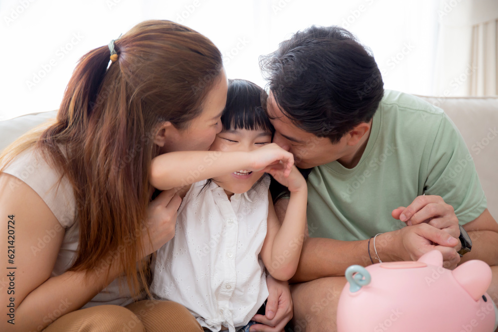 Happy asian family father and mother kiss cheek daughter sitting on sofa in living room at home, dad and mom and kid sitting and relax with comfortable on couch, lifestyles and relation concept.