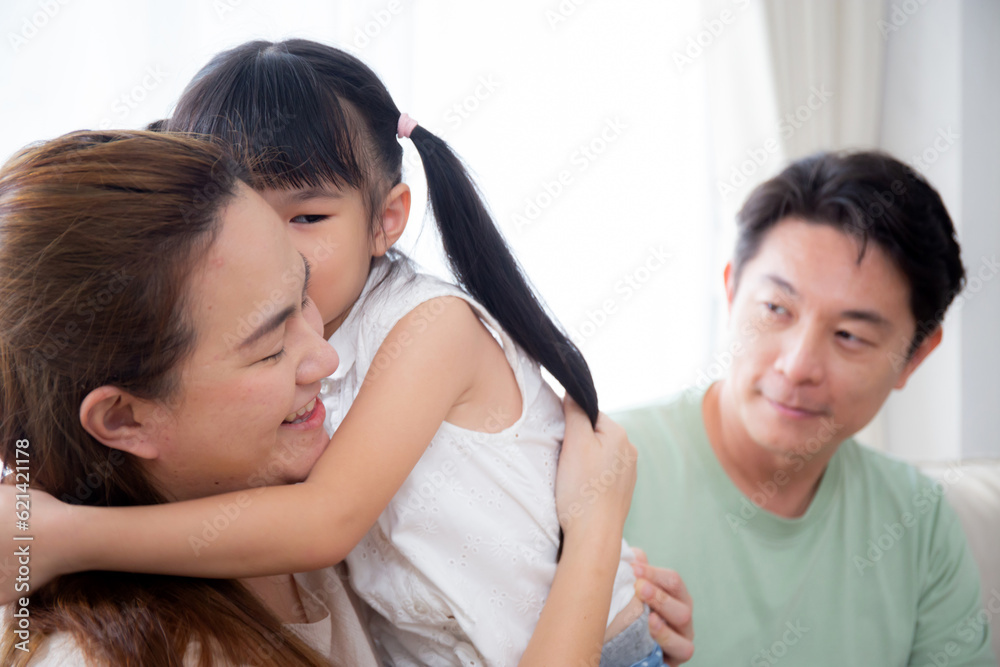 Happy asian family daughter kiss cheek father and mother sitting on sofa in living room at home, dad and mom and kid sitting and relax with comfortable on couch, lifestyles and relation concept. Happy asian family daughter kiss cheek father and mother sitting on sofa in living room at home, dad and mom and kid sitting and relax with comfortable on couch, lifestyles and relation concept.