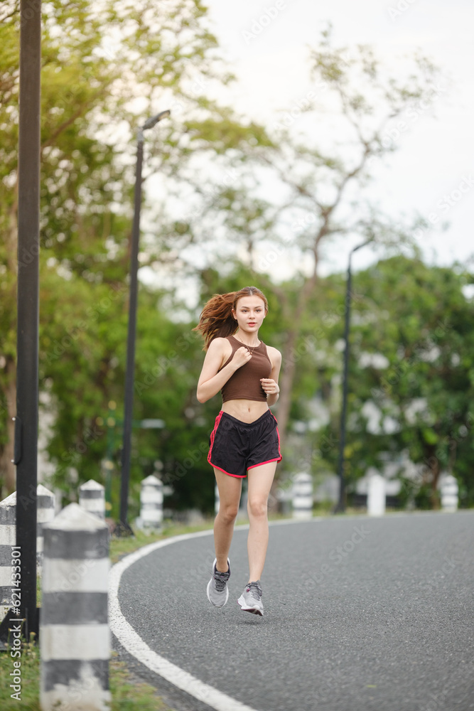 Healthy Asian woman is jogging running outdoor. Sport girl running. Female exercising at outdoor park. Sunset or Sunrise. Healthy Asian woman is jogging running outdoor. Sport girl running. Female exercising at outdoor park. Sunset or Sunrise.