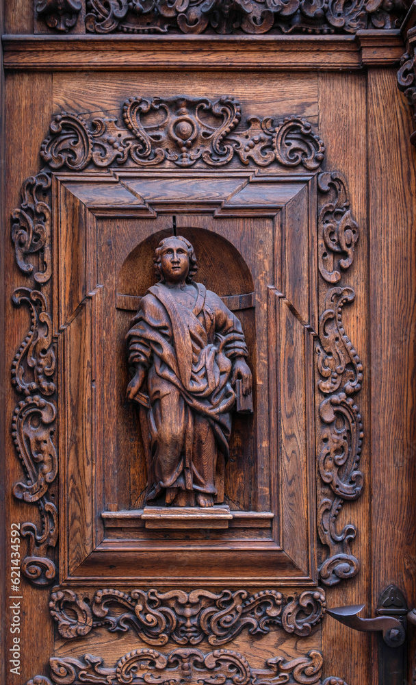 Fragment of a page door with beautiful wooden symbols and carvings. Beautiful historical wooden door from the old town of Tallinn, Estonia